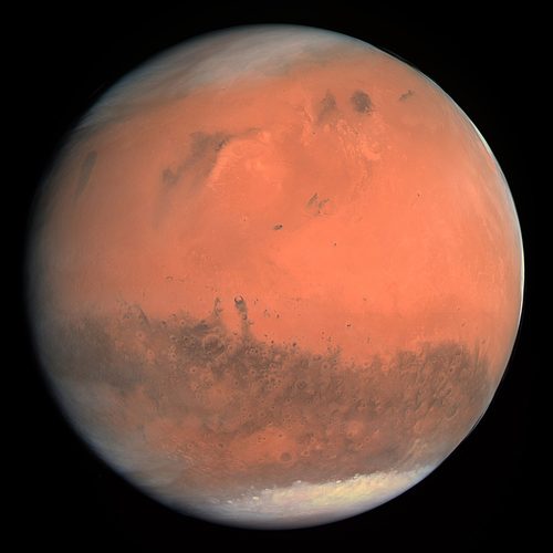 Mars in true colour, a rust-orange globe with dark surface markings